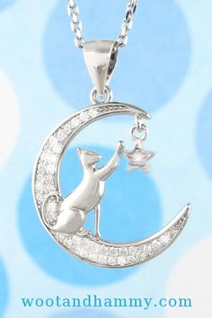 She's leaped up to the bottom edge of a crescent moon to get high enough to reach a twinkling star - much the same way you might have seen your own cat reach up for a Christmas ornament or something dangling off the edge of the table.  The moon and star are both accented with cubic zirconia crystals for sparkle while the cat's sleek form is smooth and polished. The star dangles, too, and makes the pendant come alive. Silver Crystal Star Jewelry, Silver Crescent Jewelry With Cubic Zirconia, Silver Crescent Cubic Zirconia Jewelry, Silver Diamond Jewelry With Moon Charm, Silver Moon-shaped Diamond Jewelry, Silver Diamond Moon-shaped Jewelry, Silver Moon Shaped Diamond Jewelry, Silver Cubic Zirconia Moon Necklace, Cat Reaching