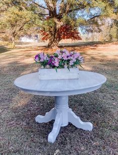 a cake sitting on top of a white table in the middle of a grass field