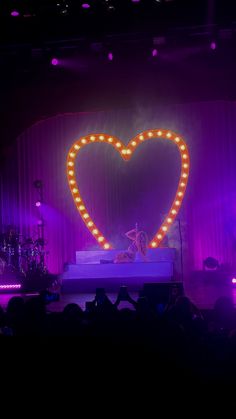 the stage is lit up with lights and a heart shaped sign on it's side