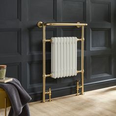 an antique style radiator in a room with dark walls and wood floors, along with a blanket on the floor