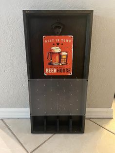 an old fashioned beer dispenser with two mugs on it's side