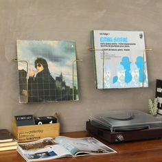 a record player sitting on top of a wooden table next to a cd player and album