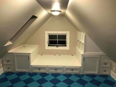 an attic bedroom with blue and white checkered flooring, built in desks