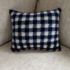 a blue and white pillow sitting on top of a couch