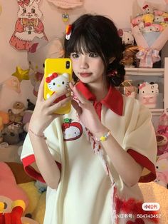 a woman holding a cell phone up to her face in front of a wall with stuffed animals