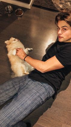 a woman sitting on the floor petting a dog