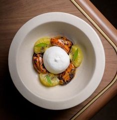 a white bowl filled with food on top of a wooden table