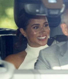 a man and woman sitting in the back seat of a car