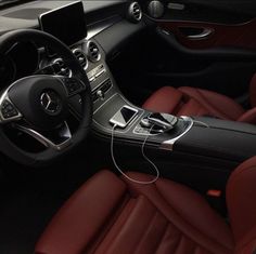 the interior of a car with red leather seats and steering wheel, including an mp3 player