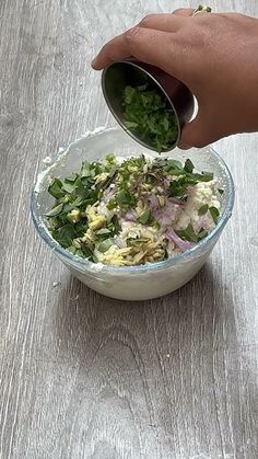 a person is pouring dressing into a bowl