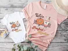 "Get ready for a fall celebration with our delightful Matching Mommy and Me Pumpkin Spice T-Shirts! Designed to capture the joy and flavor of the season, these t-shirts proudly say \"We're a Perfect Match\" in a retro groovy font, and showcase the charming graphic of a pumpkin and pumpkin spice latte as retro mascot characters. These Mommy And Me Shirts are the perfect way to embrace the Fall spirit with style and a sprinkle of fun. Ideal for a family Halloween event or a Thanksgiving gathering, these Pumpkin Spice Shirt options will make you and your little one the talk of the town. Crafted with love and a passion for Pumpkin Spice Latte, these t-shirts are more than just a fashion statement; they're a celebration of the bond between mom and child. They make a wonderful Mom And Son or Mom Graphic Print Tops For Birthday In Fall, Family Matching Pink Tops For Fall, Cute Fall Birthday Tops, Retro Groovy Font, Retro Mascot, Mom And Baby Outfits, Thanksgiving Gathering, Mommy And Me Shirts, Love Twins