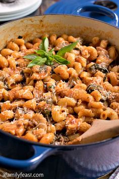 a blue pot filled with pasta and spinach