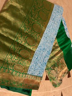 two green and blue sari's sitting on top of each other