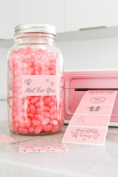 a jar filled with pink candies next to a toaster oven and label that says not for you