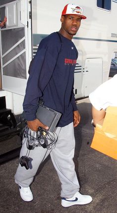 a man is walking in front of a trailer with his luggage and headphones on