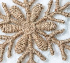 a snowflake made out of twine and rope on top of the snow