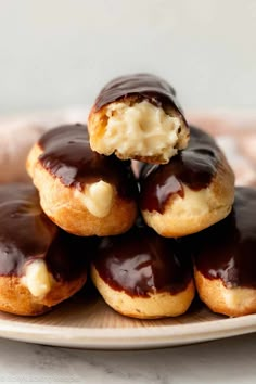 chocolate covered doughnuts stacked on top of each other with cream filling and chocolate icing