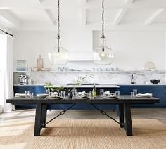 a dining room table and chairs in front of an open kitchen area with blue cabinets