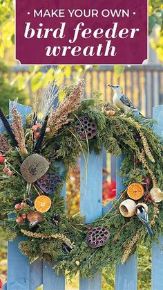 a bird feeder wreath on top of a blue fence