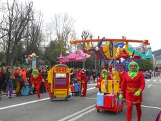 some people in costumes are walking down the street with suitcases and luggage on wheels