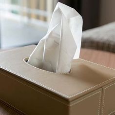 a tissue dispenser sitting on top of a wooden table