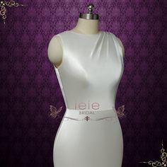 a white dress on a mannequin with purple wallpaper in the back ground