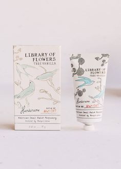 a tube of hand cream sitting next to a box on a white surface with an image of birds and flowers