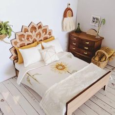 a bed with white sheets and pillows on top of it next to a wooden dresser