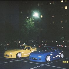 two cars parked in a parking lot at night