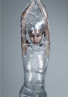 a woman wrapped in plastic with her hands behind her head