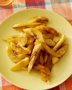 a plate full of french fries sitting on a table with a red and white checkered table cloth