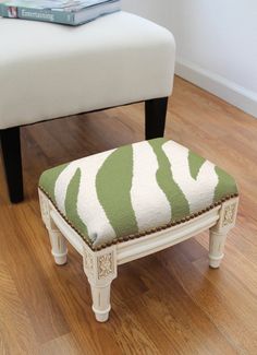 a white bench with a green and white ottoman