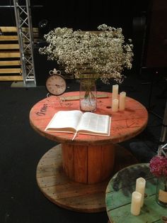 an open book on a table with flowers and candles