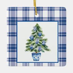 a blue and white plaid christmas ornament with a tree on it's side