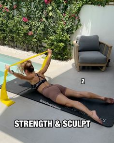 a woman is doing exercises on a mat by the pool with her arms in the air