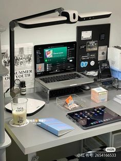 a laptop computer sitting on top of a desk next to a phone and other items