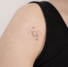 small saturn tattoo on the left shoulder