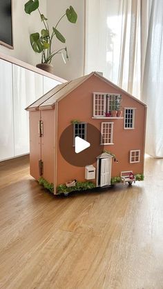 a doll house made out of cardboard on the floor