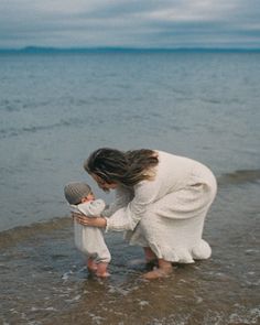 a mother and her child playing in the water