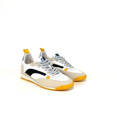 a pair of white and yellow sneakers on a white background