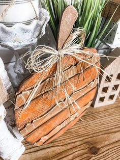 an orange pumpkin sitting on top of a wooden table next to some plants and other decorations