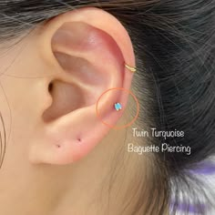 an ear piercing with two tiny blue stones