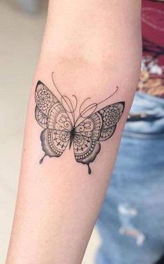 a woman's arm with a butterfly tattoo on the left side of her arm