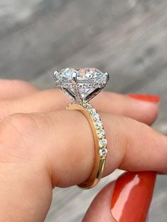 a woman's hand holding an engagement ring with two diamonds on the top and bottom