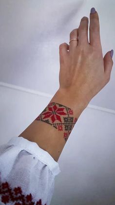 a woman's hand with a tattoo on her left wrist and the other arm