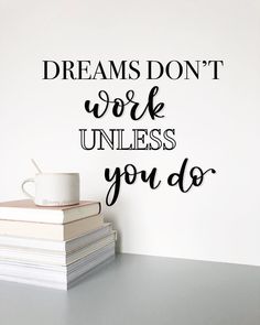 a stack of books sitting next to a coffee mug on top of a table with the words dreams don't work unless you do