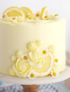 a white cake with lemons and daisies on top