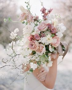 a woman holding a bouquet of flowers in her hands