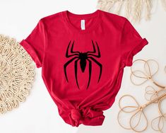 a red t - shirt with a black spider on it