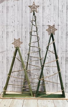 two small wooden christmas trees with star decorations on them, sitting next to each other